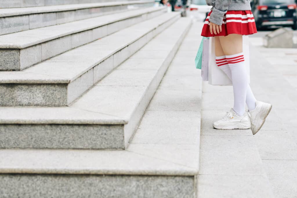 Image of schoolgirl in short skirt and thigh high socks walking up the stairs