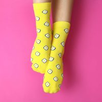 Female legs in funny socks on pink background